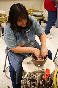 Student working at a pottery wheel
