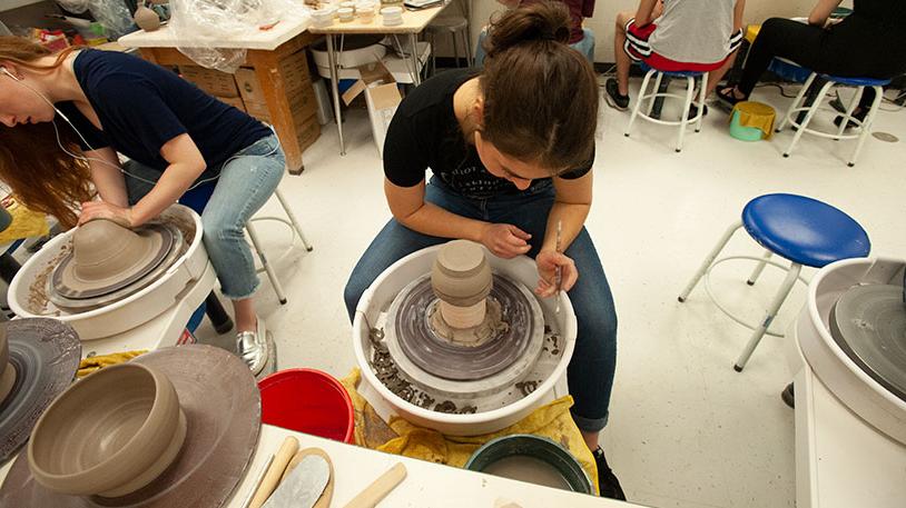 students working at a pottery wheel